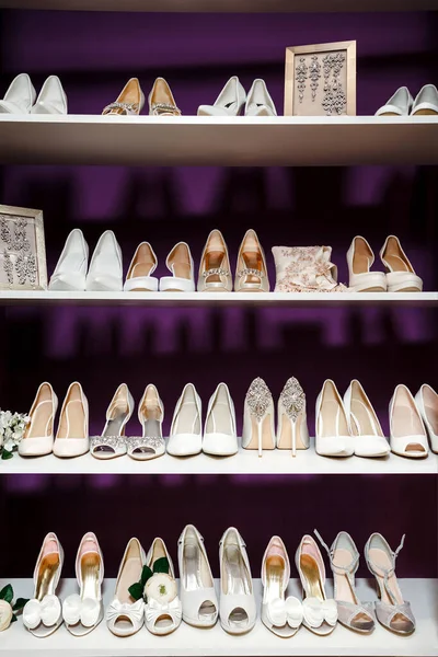 stock image stylish wedding shoes and details of the bride on a shelf in the store on a purple background