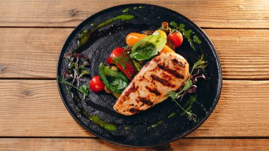 Lezzetli bir tabağı var. Domates, kızarmış biftek, biraz yaprak ve yeşil sos görebiliriz. Yemek harika ve lezzetli görünüyor. Müşteriye servis edilir..