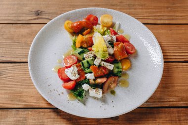 Restoranda bir vejetaryen yemeği var. Bir sürü sebze var, domates, salatalık, biber gibi. Lezzetli görünüyor ve biraz sos ve yağ dökülüyor..