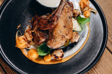 Restoranda müşterinin önünde kremalı lezzetli bir yemek var. Çok şehvetli ve lezzetli görünüyor. Tabakta büyük, lezzetli bir kızarmış tavuk ve yapraklı kızarmış patates görebiliyoruz..