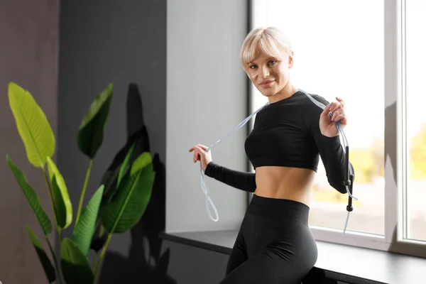 Spor giysili şirin bir kadın elinde ip tutuyor. Sağlıklı yaşam tarzı, yoga, spor, spor.