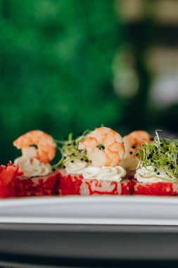 Havyar, yeşillik ve karidesle süslenmiş beyaz bir tabakta karides suşisi..