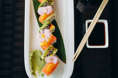 Japon suşi mutfağı. Somon, karides, yengeç ve avokado ile rulo. Suşi çeşitliliğinin en üst görüntüsü. Gökkuşağı suşi rulosu.