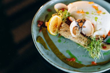 Mavi tabakta patates püresi ve limon dilimleri ve koyu arkaplanda kızarmış morina balığı. Yukarıdan görüntüle.