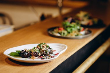 Fındık, fındık ve yeşil soğanla doldurulmuş, balzamik sosla süslenmiş patlıcan..