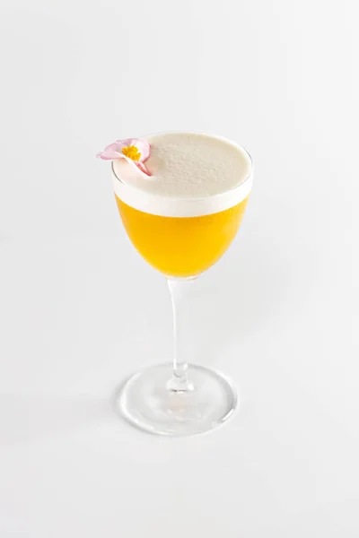 白色底色上有黄色柠檬鸡尾酒的杯子 饮料上装饰着花 — 图库照片