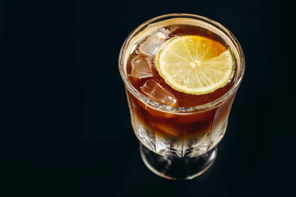 黒の背景にアイスブラックコーヒーとオレンジとレモンジュースの層のガラス — ストック写真