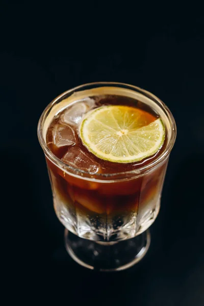 黒の背景にアイスブラックコーヒーとオレンジとレモンジュースの層のガラス — ストック写真