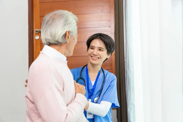 stock image Friendly staff caregiver of nursing home talking to asian senior