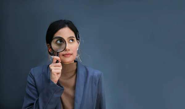 Businesswoman Looking Magnifying Glass Grey Wall Background Copy Space — Stock Photo, Image