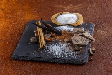 Çikolata parçaları ve içindeki malzemeler, kırsal elementlerle dolu bir levhada..