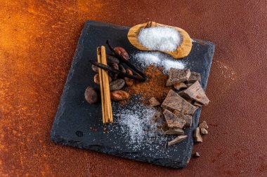Çikolata parçaları ve içindeki malzemeler, kırsal elementlerle dolu bir levhada..