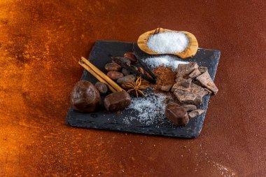 Çikolata parçaları ve içindeki malzemeler, kırsal elementlerle dolu bir levhada..