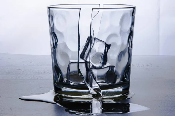 Gebroken Glas Twee Helften Met Drie Ijsblokjes Gefotografeerd Witte Achtergrond — Stockfoto