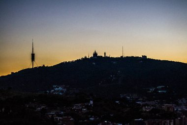 Barselona 'nın Tibidabo Dağı' nın Turo de la Rovira adlı tepeden çekilmiş gece manzarası. Yazın başında gün batımı.