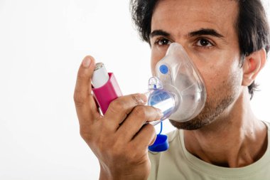 Hindistan 'dan Asya' lı genç bir adam solunum cihazı kullanıyor. Beyaz arkaplan üzerinde çalış, seçici odak.