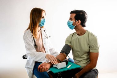 Hintli bir Asyalı hastaya kan basıncını ölçen kadın doktor. Beyaz arkaplan.