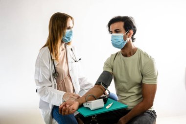 Hintli bir Asyalı hastaya kan basıncını ölçen kadın doktor. Beyaz arkaplan.