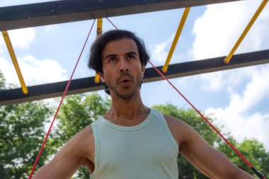 Bir adam direniş bandıyla egzersiz yapıyor.