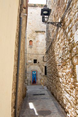Girona 'nın Yahudi Mahallesi' nde dar bir sokak ve taş bina manzarası, ortaçağ mimarisi ve tarihi mirası vurguluyor..