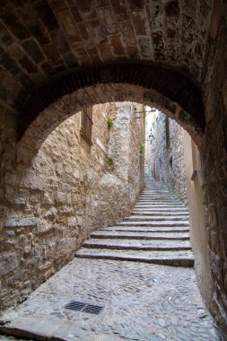 Ortaçağ mimarisi ve kültürel mirasının altını çizerek Girona 'nın tarihi Yahudi mahallesinde taş basamakların ve kemerli bir geçitin manzarası.