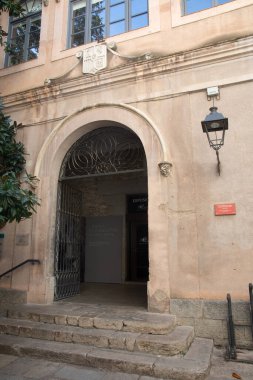 Girona 'daki Eski Enstitü' nün tarihi girişi, karmaşık işlenmiş demir işçiliği ve taş merdiveni olan kemerli bir kapı aralığı sergiliyordu..