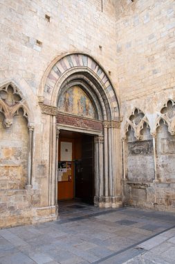 Girona 'daki Basilica de Sant Feliu' nun girişi, Gotik mimarisini ve kapının üzerindeki tarihi freskleri gözler önüne seriyor..