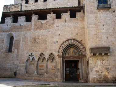 Girona 'daki Sant Feliu Bazilikası' nın Gotik girişine yakın çekim, karmaşık taş işçiliği ve antik fresklerin yer aldığı.