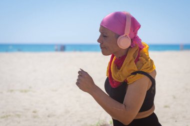 Close-up of a cancer patient's fitness session on the beach, showing strength and determination clipart