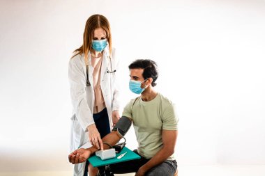 Hintli bir Asyalı hastaya kan basıncını ölçen kadın doktor. Beyaz arkaplan.