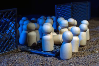 Çitin yanında toplanan ahşap heykelcikler göç sorunlarını ve özgürlük mücadelesini simgeliyor..