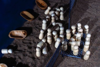 Small wooden boats and figurines on sand divided by fences, evoking the struggles and emotional toll of migration. clipart