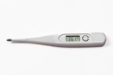 Dijital termometre, beyaz bir yüzeye yerleştirilmiş 36.1 C sıcaklığı gösteriyor..