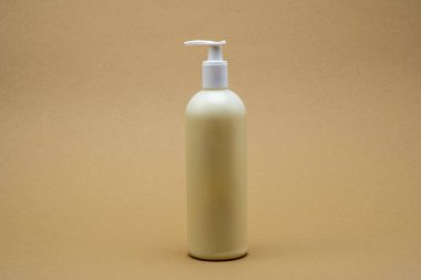 Nötr Arkaplan Pompalı Plastik Şişe Tarafsız Bej arka planda beyaz pompalı basit plastik şişe. Güzellik, hijyen veya cilt ürünleri için ideal.