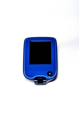 Beyaz bir yüzeyde uzanan boş ekranlı taşınabilir insülin pompası sürekli glikoz izleme için diyabet yönetimi ve sağlık teknolojisini temsil etmektedir.