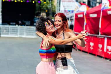 İki kadın bir gurur etkinliğinde dans ediyor ve kucaklaşıyorlar, aşklarını, mutluluklarını ve lgbtq artı kutlamaları tanımlayan kapsayıcılık ruhunu sergiliyorlar.