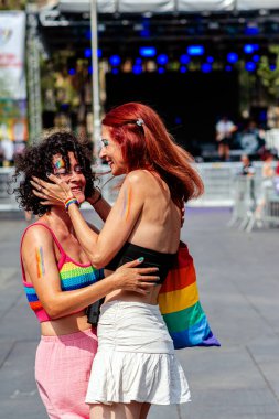 İki kadın bir geçit töreninde sevgi gösteriyorlar. Aşkı, kapsayıcılığı ve Igbtq artı hakları coşkulu ve neşeli bir atmosferde kutluyorlar.