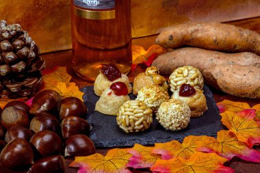 Küçük sanat panelleri, kestaneler, tatlı patatesler ve sonbahar yapraklarıyla dolu bir masada bir şişe tatlı şarap sergilenerek Castanyada geleneğini kutluyoruz.