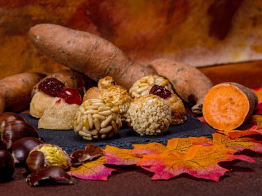 Geleneksel katalan tatlıları, kavrulmuş tatlı patatesler, kestaneler ve renkli sonbahar yaprakları, Katalonya, İspanya 'da ölülerin gecesinin kutlandığı, Castanyada için şenlikli bir sahne oluşturur.