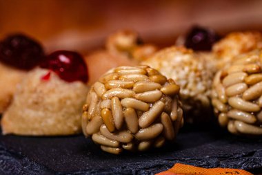 Çam fıstığıyla kaplı lezzetli panelleri kapatın. Diğer geleneksel şekerlerle birlikte koyu bir tabakta sergilenerek Castanyada geleneğini kutlayın.