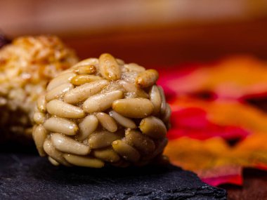 Geleneksel çam fıstığı kaplı paneller, Katalonya, İspanya 'da Castanyada' yı kutluyorlar, sonbahar yaprakları ve bulanık panellerle birlikte koyu bir levhada dinleniyorlar.