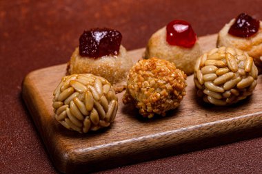 Çam fıstığı, badem ezmesi ve şekerli meyve panelleri tahtanın üzerinde duruyor. Castanyada boyunca geleneksel şekerlerin tadını çıkarıyorlar. İspanya 'da ölenlerin gecesinin katalan kutlaması.