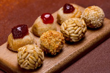 Geleneksel Castanyada tatlıları, çam fıstığı ve şekerli meyvelerle kaplı panelletler, ve bıldırcın reçelli tatlı patatesler, küçük ahşap bir tahtanın üzerinde dinlenerek, katalan mutfak mirasını kutluyorlar.