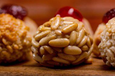 Lezzetli panellere yakın, çam fıstığı, şeker ve yumurtadan yapılmış geleneksel katalan tatlılar, ahşap bir masada oturmuş, Castanyada kutlamalarında eğlenmeye hazırlar.