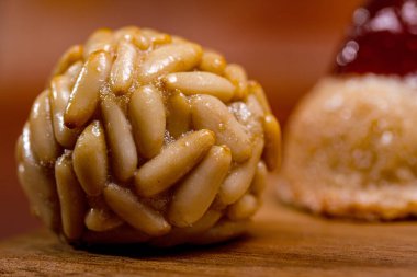 Ahşap bir tahtanın üzerinde çam fıstığıyla kaplanmış geleneksel panellere yakın. Yanında bulanık tatlı patates ve ayva pastası var. Katalonya 'nın Castanyada' sını kutluyoruz.