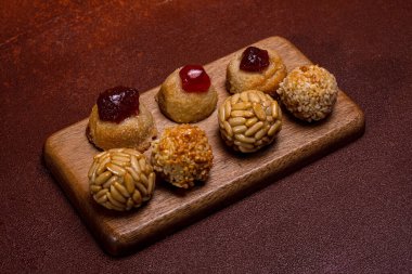 Panellet adı verilen küçük badem ezmesi ve çam fıstığı tatlısı ve tatlı patates ve ayva kekleri katalonya, İspanya 'daki Castanyada kutlamalarında eğlenmeye hazır bir tahta tahtaya uzanır.