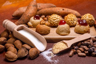 Geleneksel malzemeler ve tatlılar sergileniyor, panelletler gibi, kavrulmuş tatlı patatesler, ve bademler ahşap bir yüzeyde, katalan castanyada festivalini kutluyorlar.