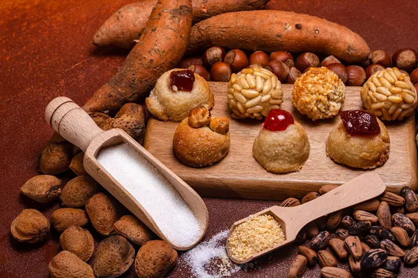 Geleneksel paneller, kavrulmuş tatlı patatesler, badem, fındık, çam fıstığı ve şeker ahşap bir tahtada ve kepçelerde sergilenerek, Castanyada 'nın katalan geleneğini kutlanır.