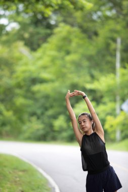 Genç bir kadın sabah antrenmanı sırasında koşu bandında ısınır. Adımları ritmik ve sabittir. Gün ağarırken spor salonunun pencerelerinden ışık akar..