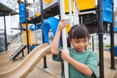 Genç kız oyun alanında eğleniyor..